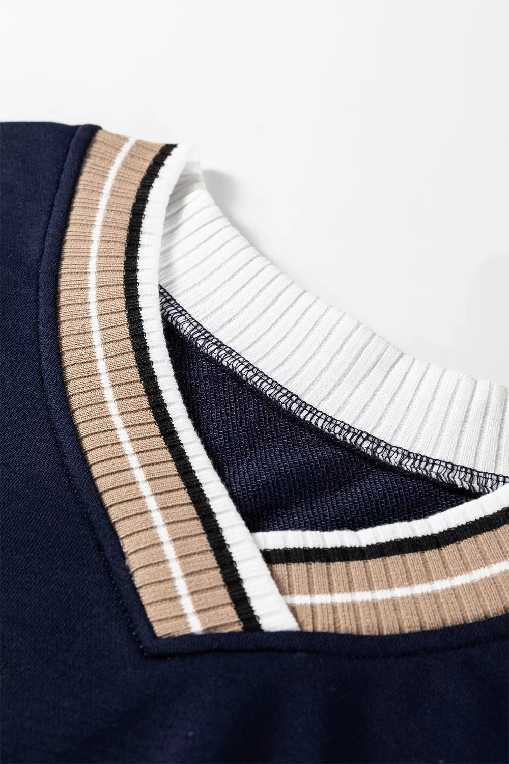Contrast striped trim V-neck sweatshirt from Trendsi featuring a relaxed fit and bold striped detailing on the neckline.