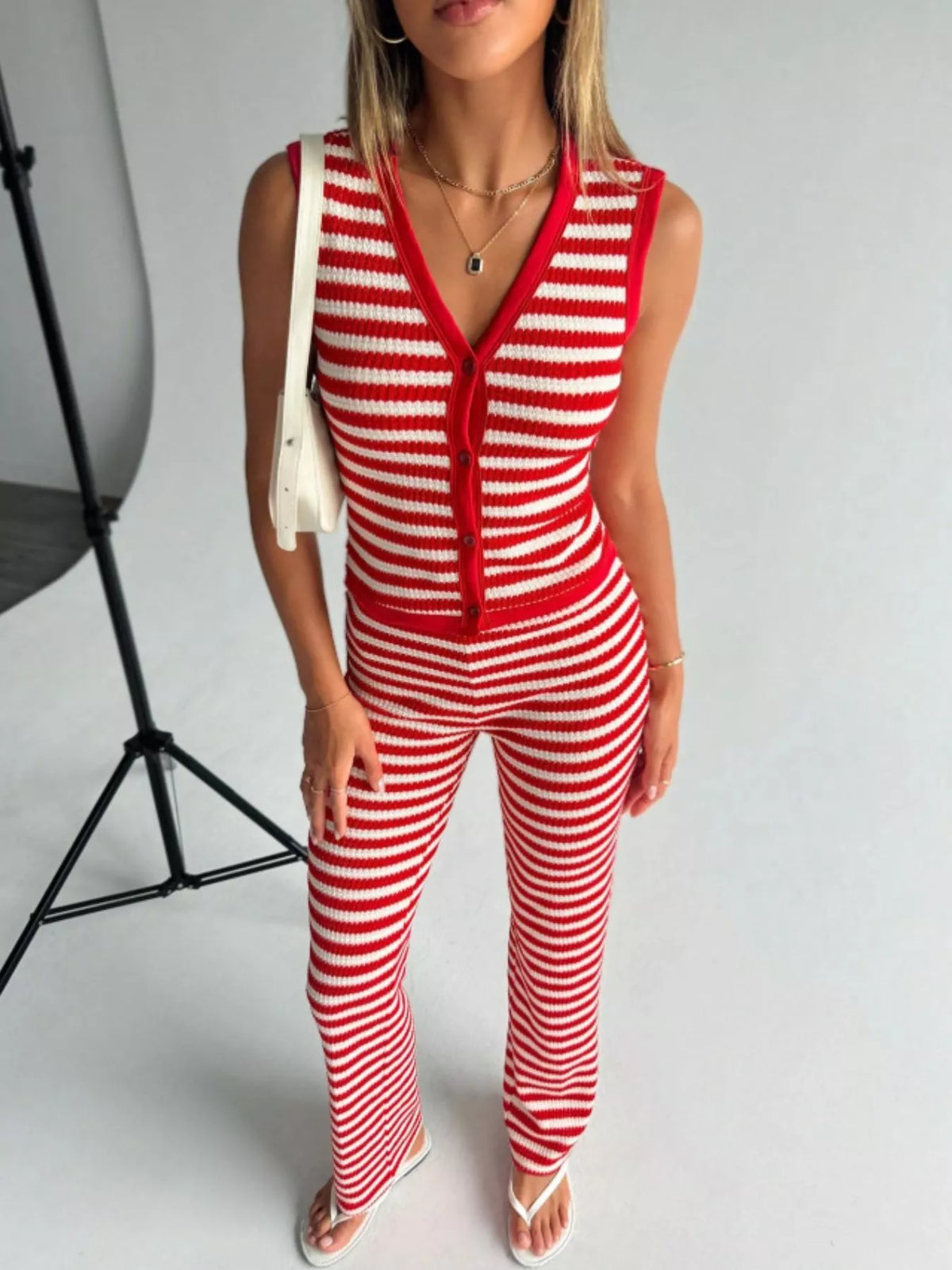 Striped knit V-neck sleeveless top and flare pants set by Plush Fashion Hub, featuring a stylish, casual summer outfit.