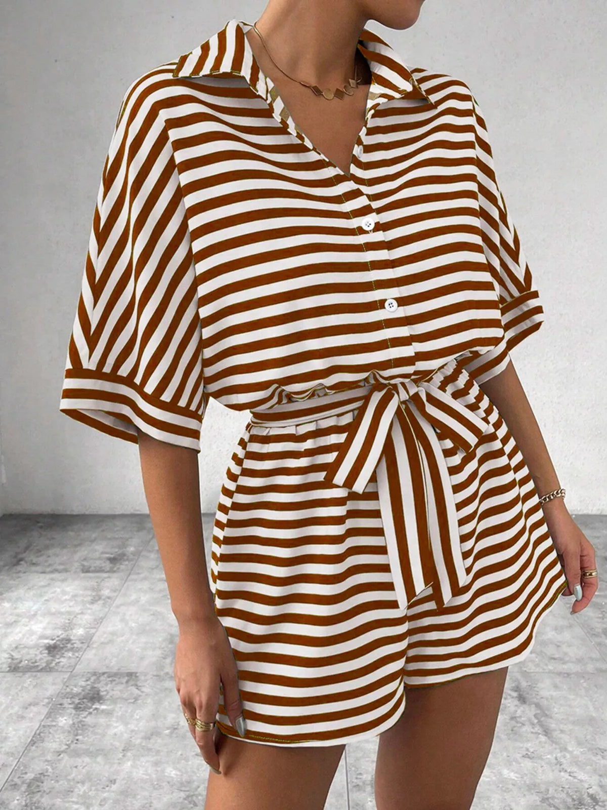 Striped button-front half sleeve romper shirt by Plush Fashion Hub, showcasing a stylish casual design with vertical stripes.