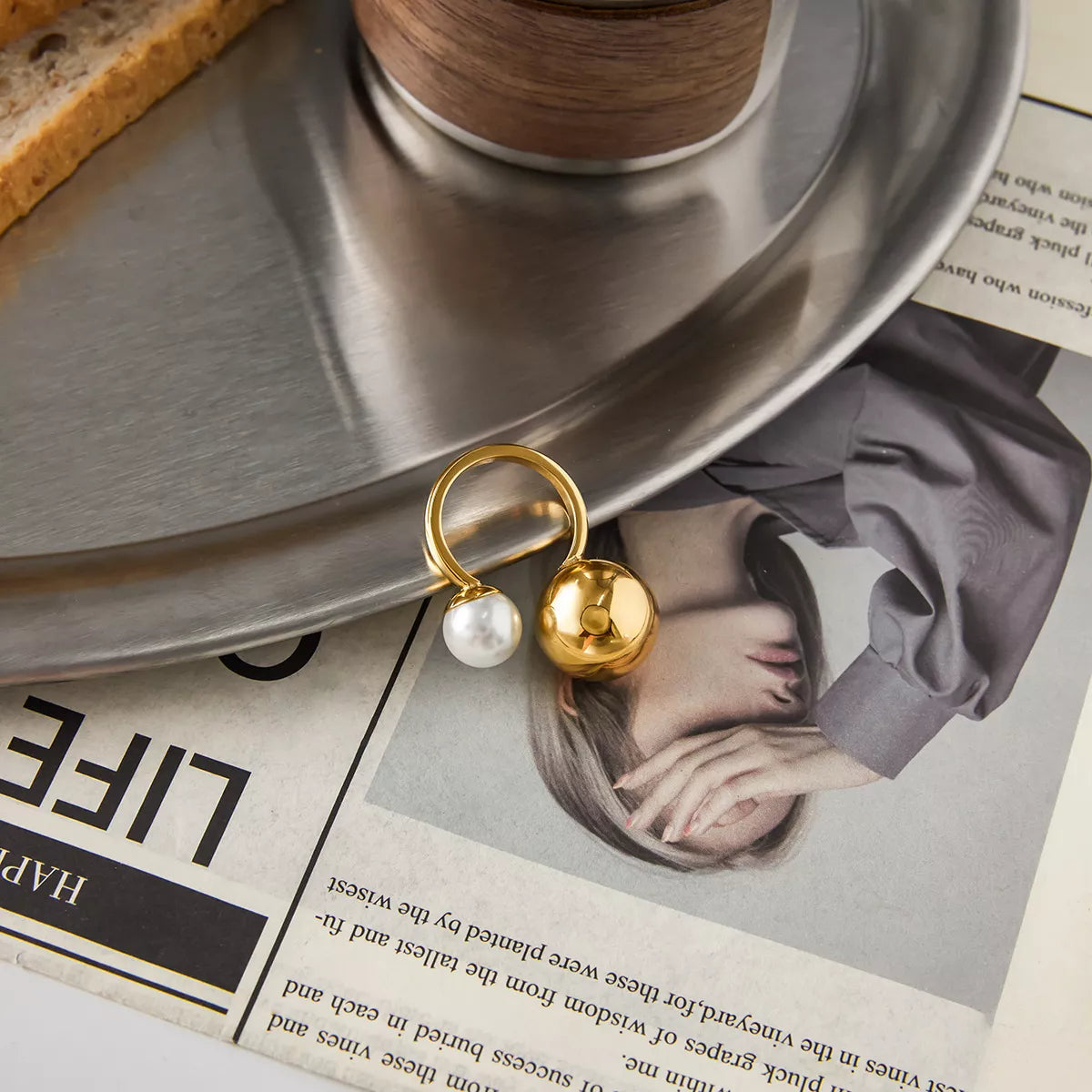 18K gold-plated orb and pearl open ring with a sleek design, featured on a ring display.