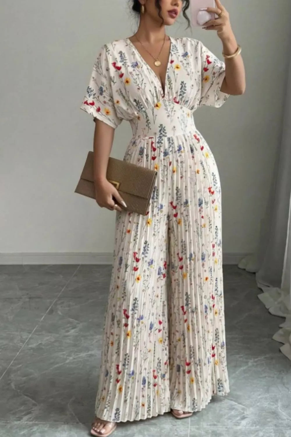 Floral print wide-leg pleated jumpsuit by Plush Fashion Hub, featuring a stylish design and flowing fabric.