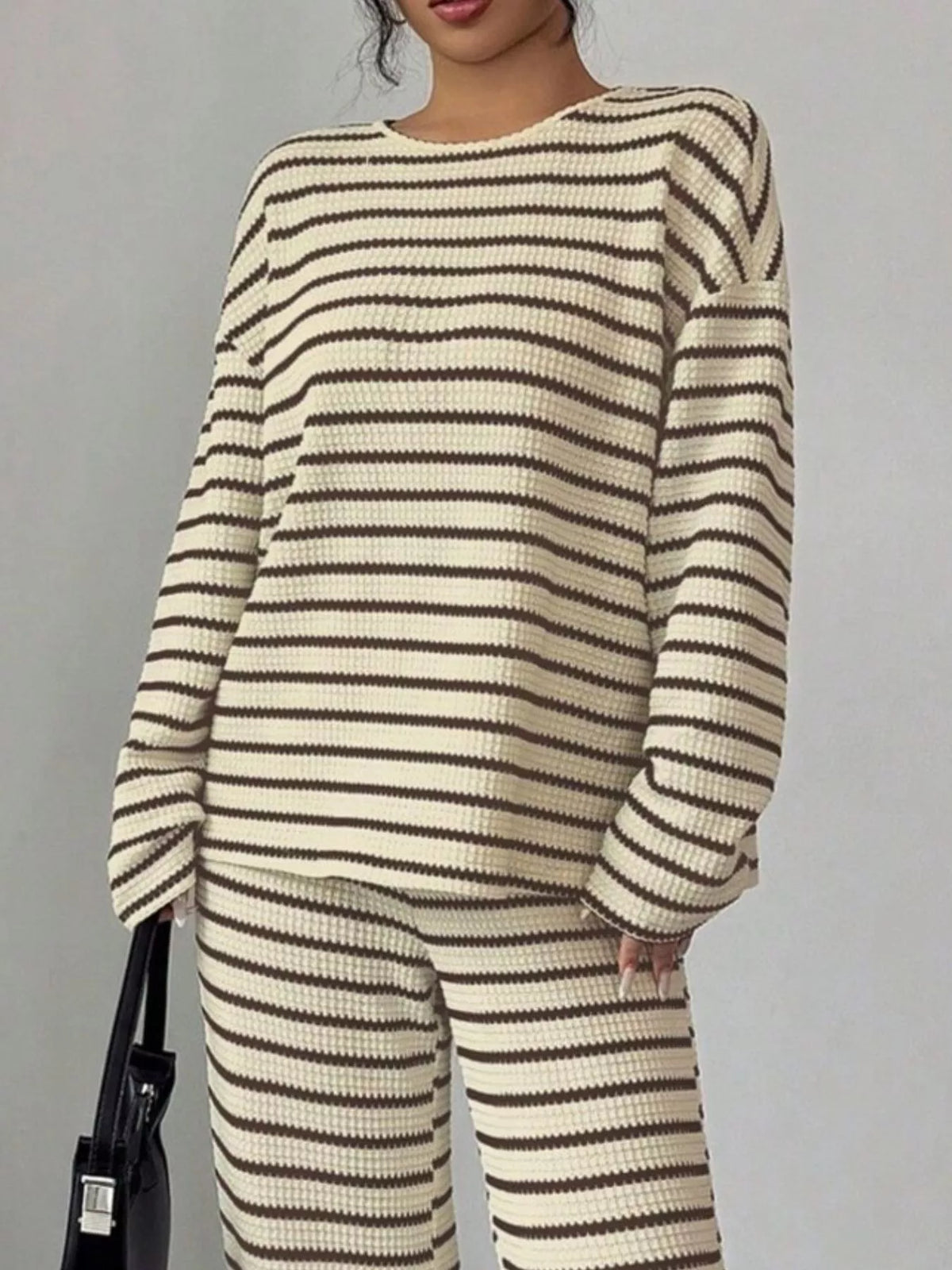 Striped knit dropped shoulder top and pants set by Trendsi, featuring a relaxed fit and comfortable, stylish design.