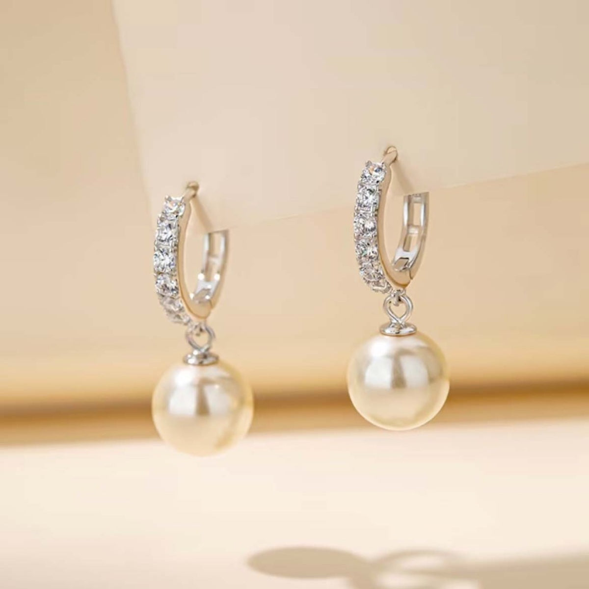 Pearl drop hoop earrings from Plush Fashion Hub featuring elegant pearl pendants and circular hoop design.