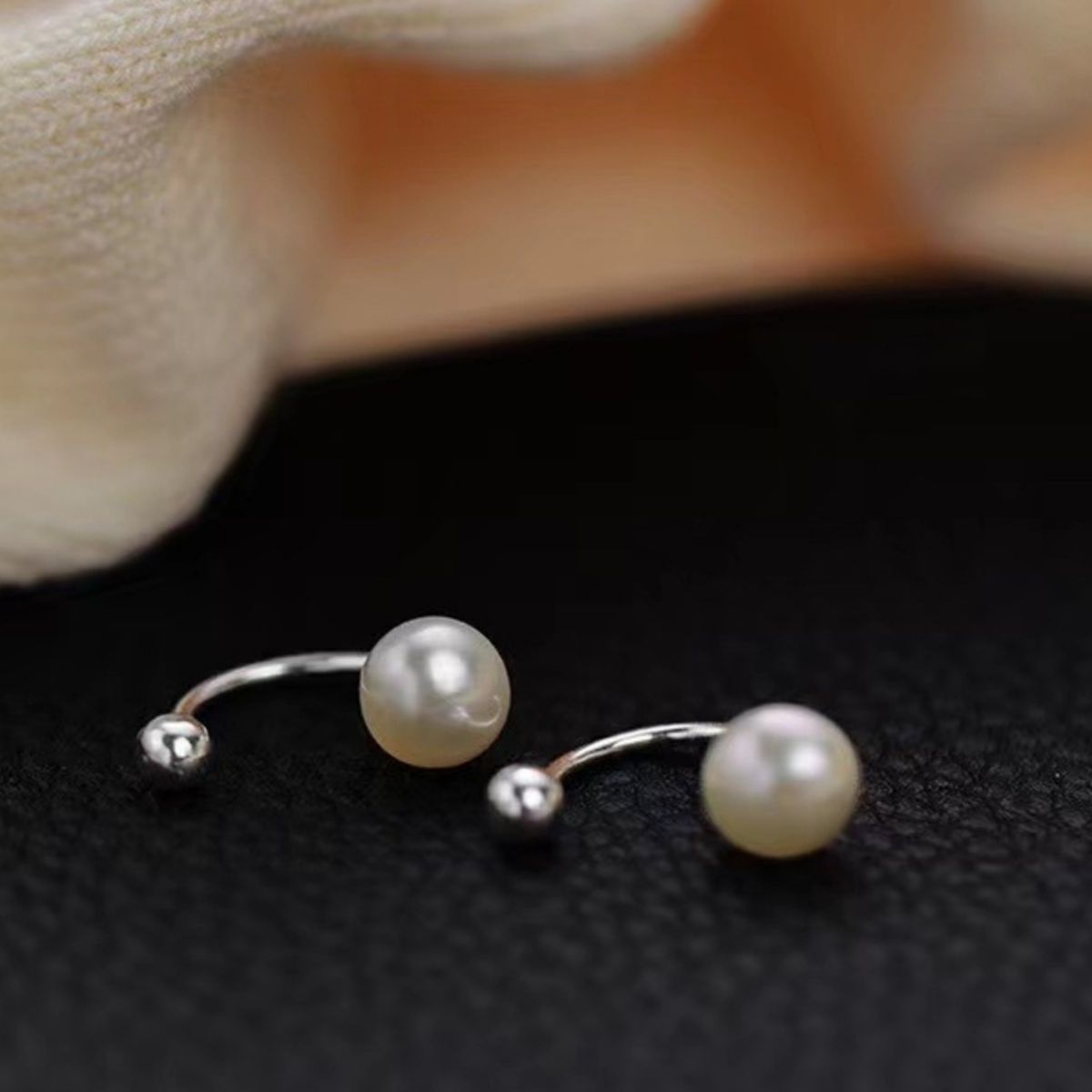 Sterling silver pearl stud earrings from Plush Fashion Hub featuring round white pearls and sleek silver settings.