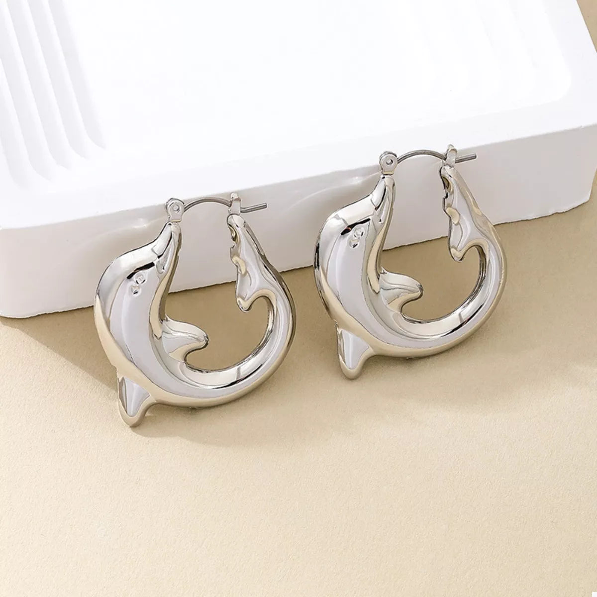 Gold-plated dolphin hoop earrings from Plush Fashion Hub with detailed dolphin design and shiny finish.