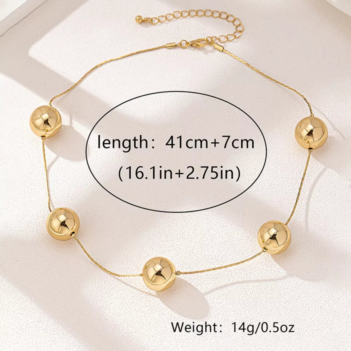 Golden sphere statement necklace by Plush Fashion Hub featuring large gold orbs on a sleek chain.