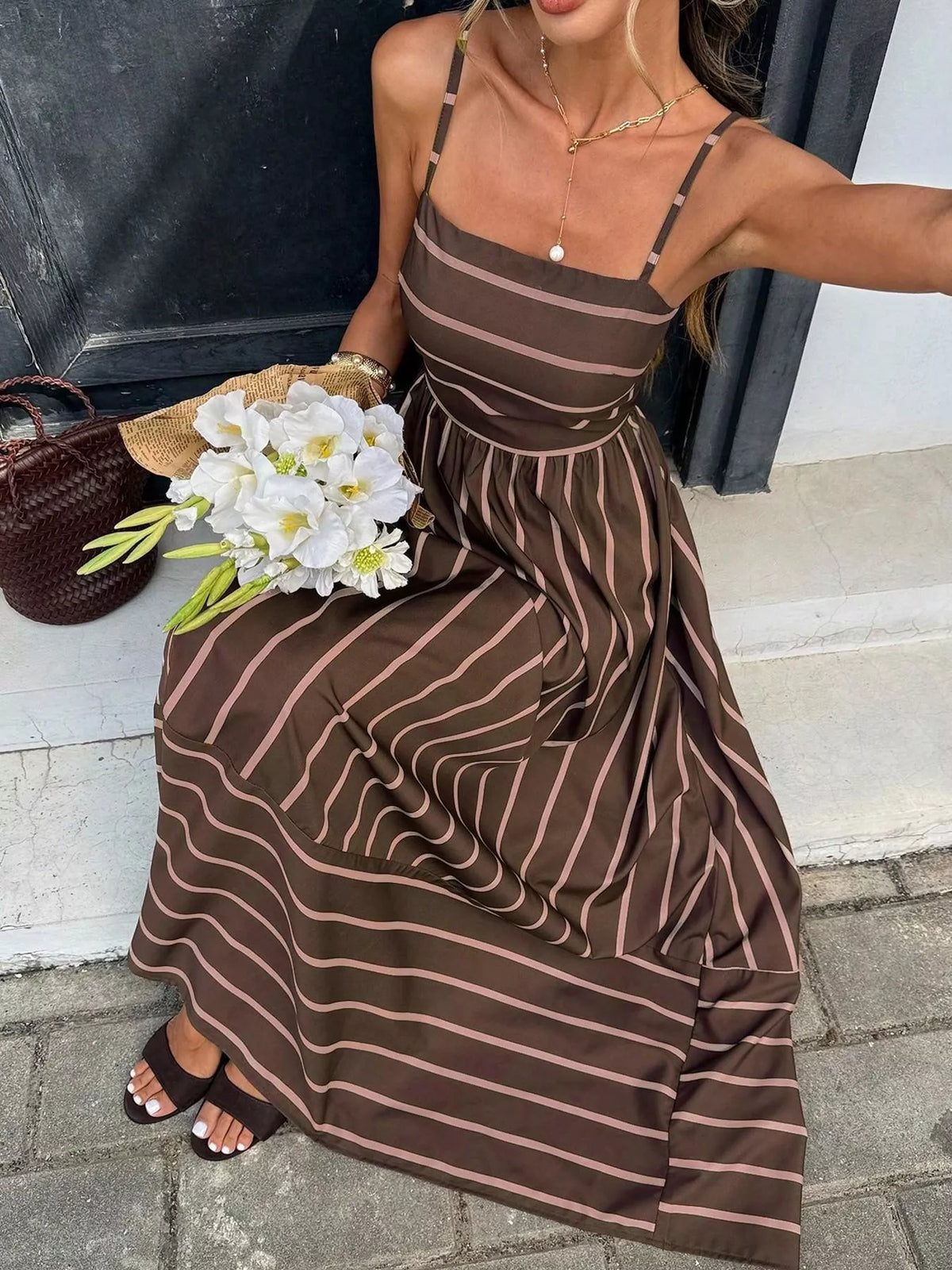 Striped cutout back maxi dress by Plush Fashion Hub featuring a flowy silhouette and bold horizontal stripes.