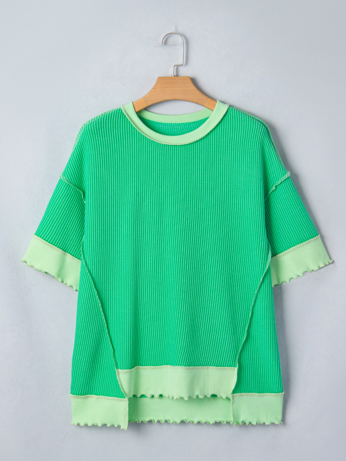 Women’s ribbed short sleeve T-shirt with twist hem and contrast stitching, by Plush Fashion Hub, shown in a close-up of the fabric and design.