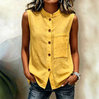 Women's sleeveless crop top by FitiqueFit with buttoned pockets in a solid color, casualwear style, shown in water-themed background.