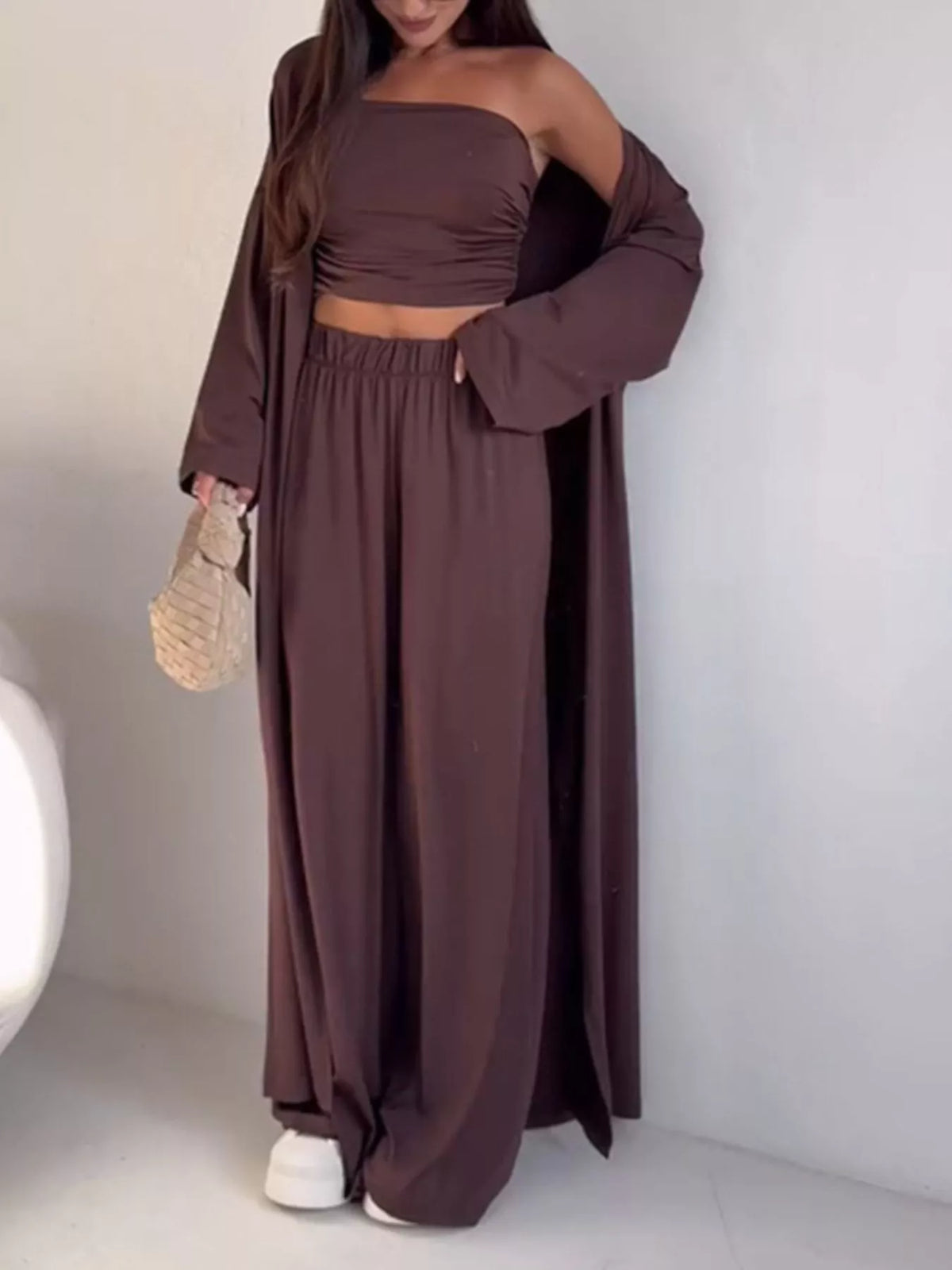 Trendsi 3-piece set featuring a strapless ruched crop top, wide-leg pants, and matching cardigan, styled together in a fashionable outfit.