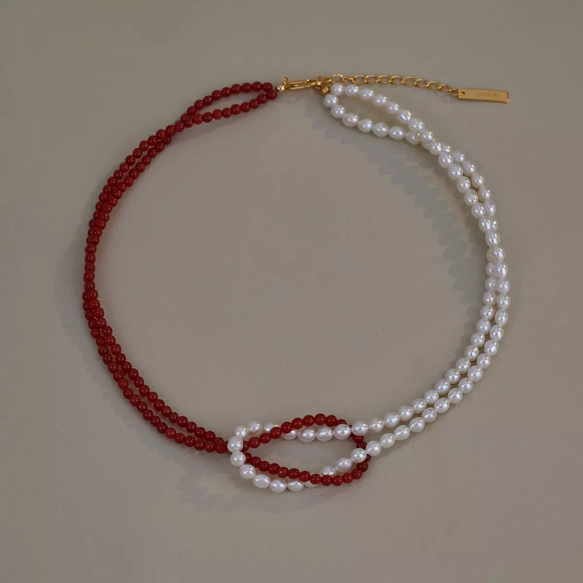 Double layered knot necklace from Plush Fashion Hub featuring intertwined silver chains on a neutral background.