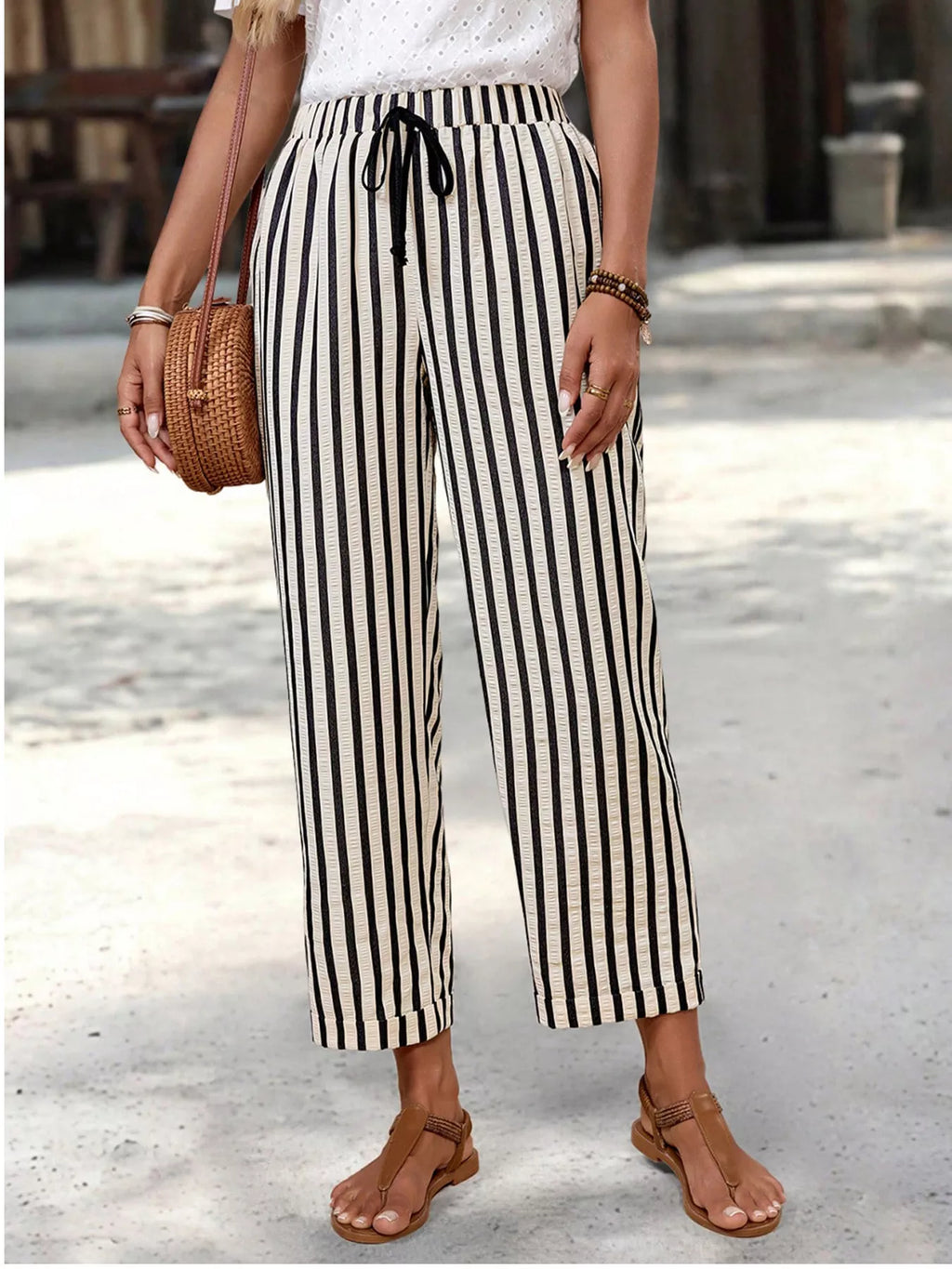 Women's striped high-waisted cropped pants with pockets, trendy bottoms by Trendsi, shown in a stylish fit on a model.