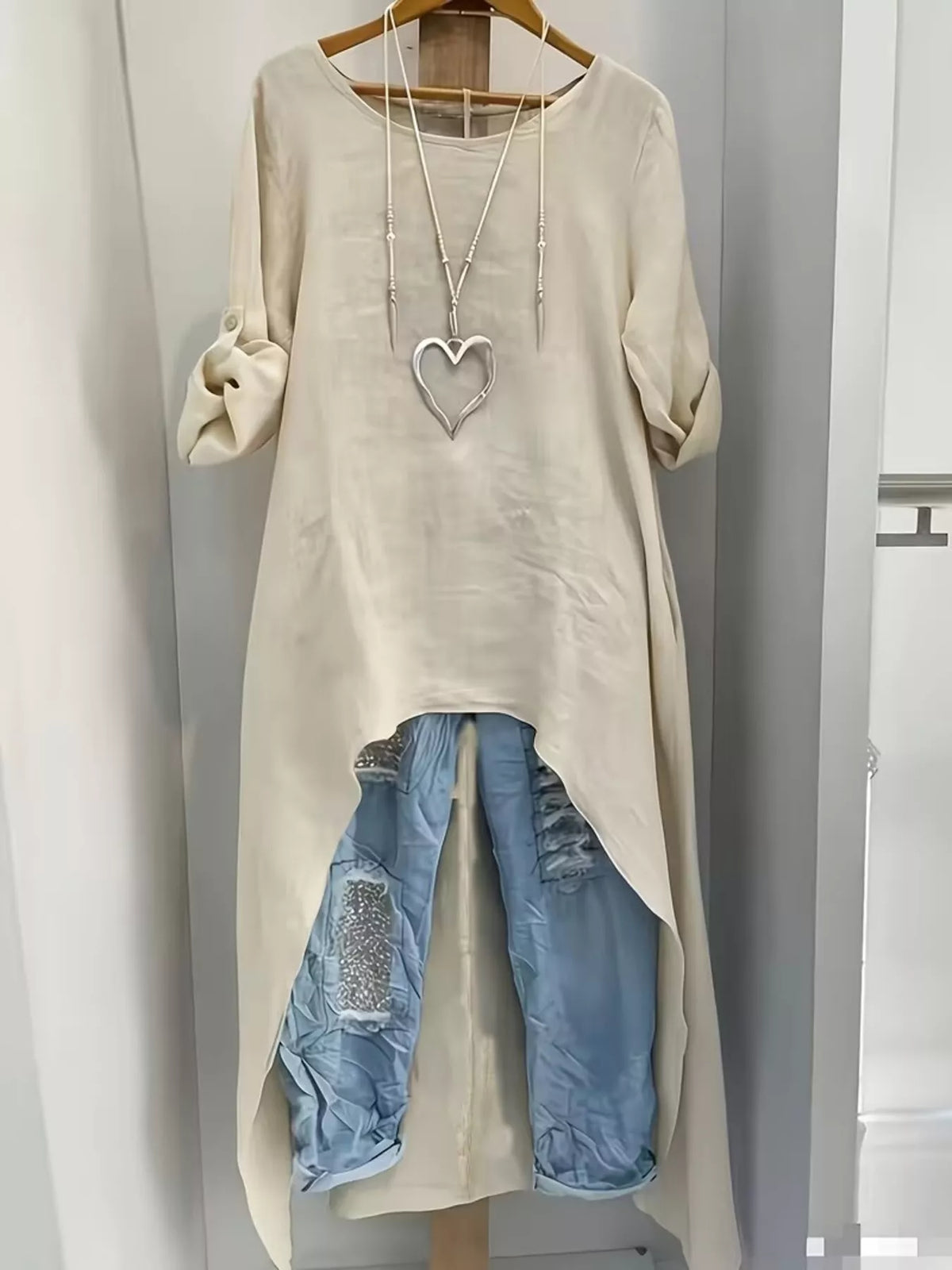 High-low hem roll-up sleeves blouse by Trendsi, featuring a stylish design with adjustable sleeves and a flowy fit.