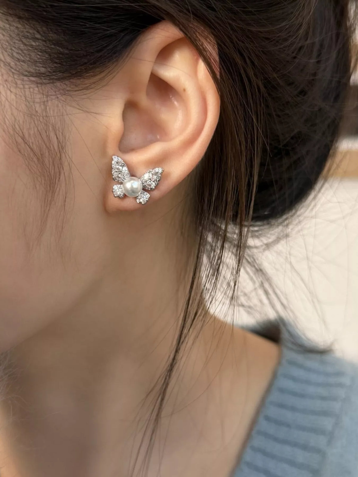 Butterfly pearl stud earrings from Plush Fashion Hub featuring elegant white pearls and butterfly-shaped design.