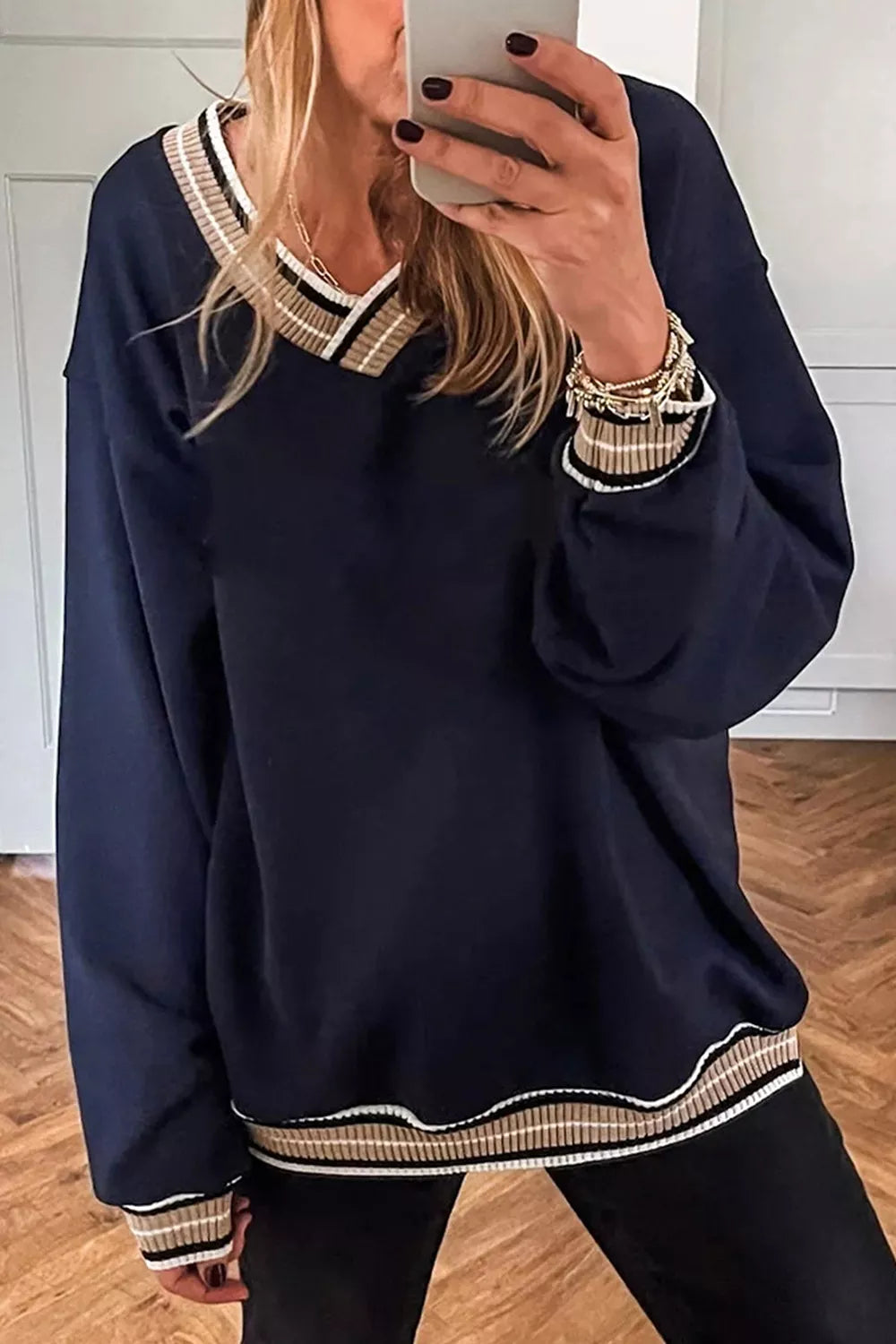 Contrast striped trim V-neck sweatshirt by Trendsi, featuring a cozy fit and stylish design with bold stripe details.