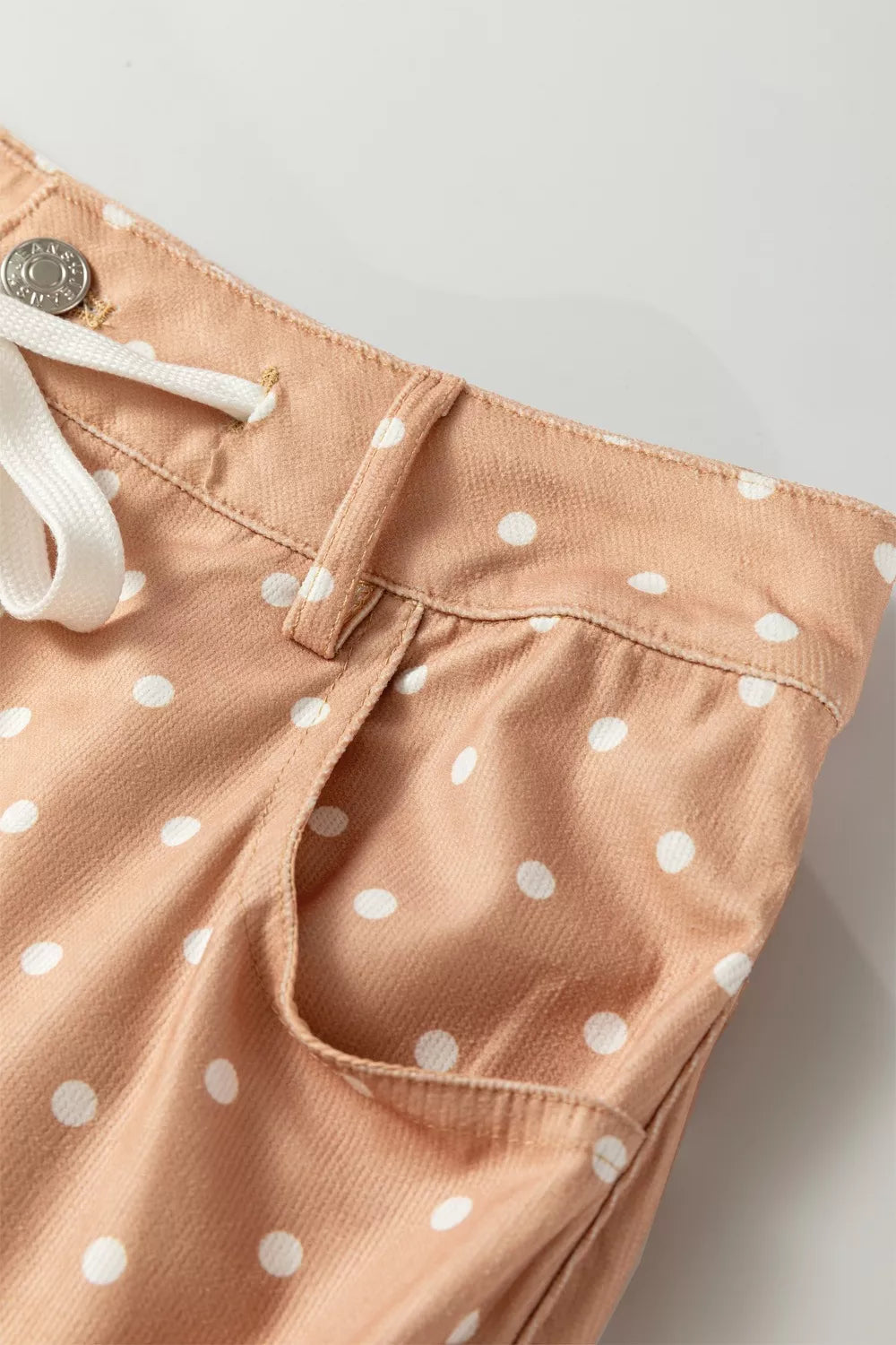 Lightweight women’s polka dot wide-leg casual trousers with drawstring waist by Plush Fashion Hub, shown in a relaxed dress style.