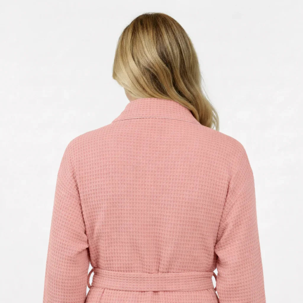 Back view of Lotus Linen women's knee-length blush waffle robe, showcasing soft fabric and comfortable fit.