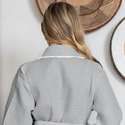 Back view of small gray knee-length waffle robe for women by Lotus Linen, featuring piping details.