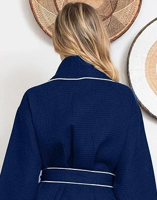 Back view of Lotus Linen navy knee-length waffle robe for women with piping, showing small size and cozy textured fabric.