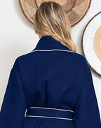 Back view of Lotus Linen navy knee-length waffle robe for women with piping, showing small size and cozy textured fabric.