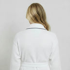 White women's waffle piping bathrobe by Lotus Linen, lightweight spa-style robe with small piping detail, shown from the back.