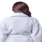 Back view of small white knee-length waffle robe for women with piping from Lotus Linen, showing the relaxed fit and textured fabric.