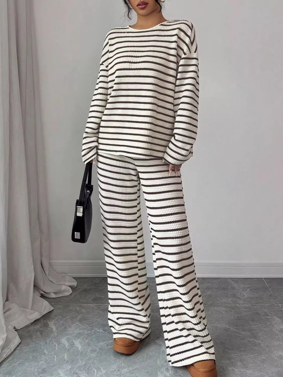 Striped knit dropped shoulder top and pants set by Trendsi, featuring a cozy, casual style with matching striped pattern.
