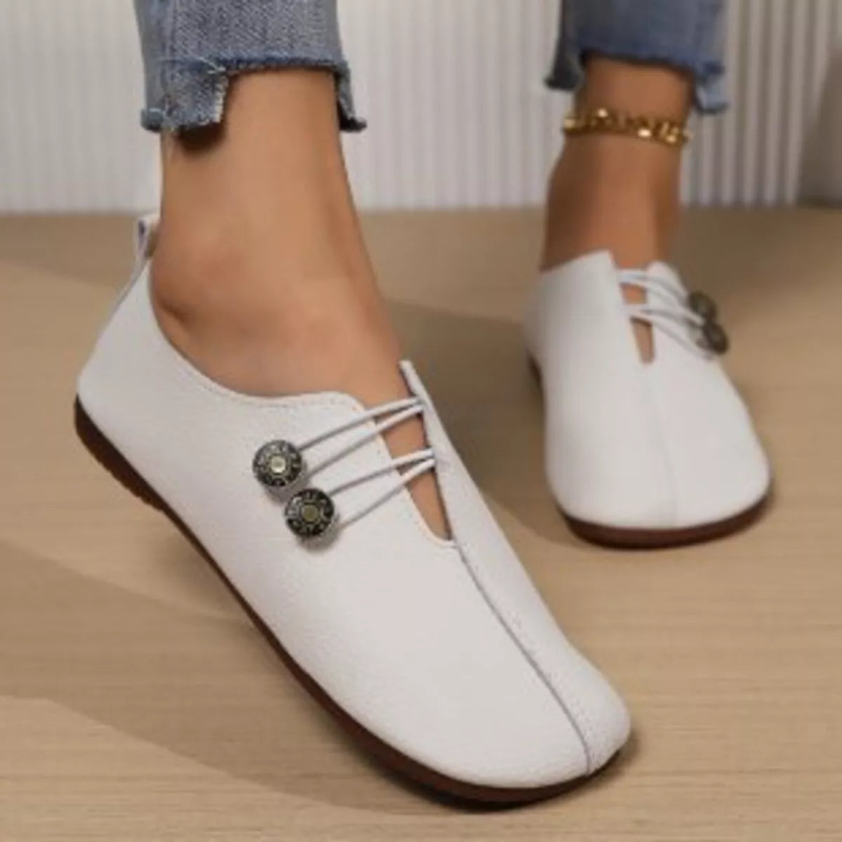Women's casual slip-on shoes with button details from Trendsi, featuring a comfortable design and stylish slip-on silhouette.
