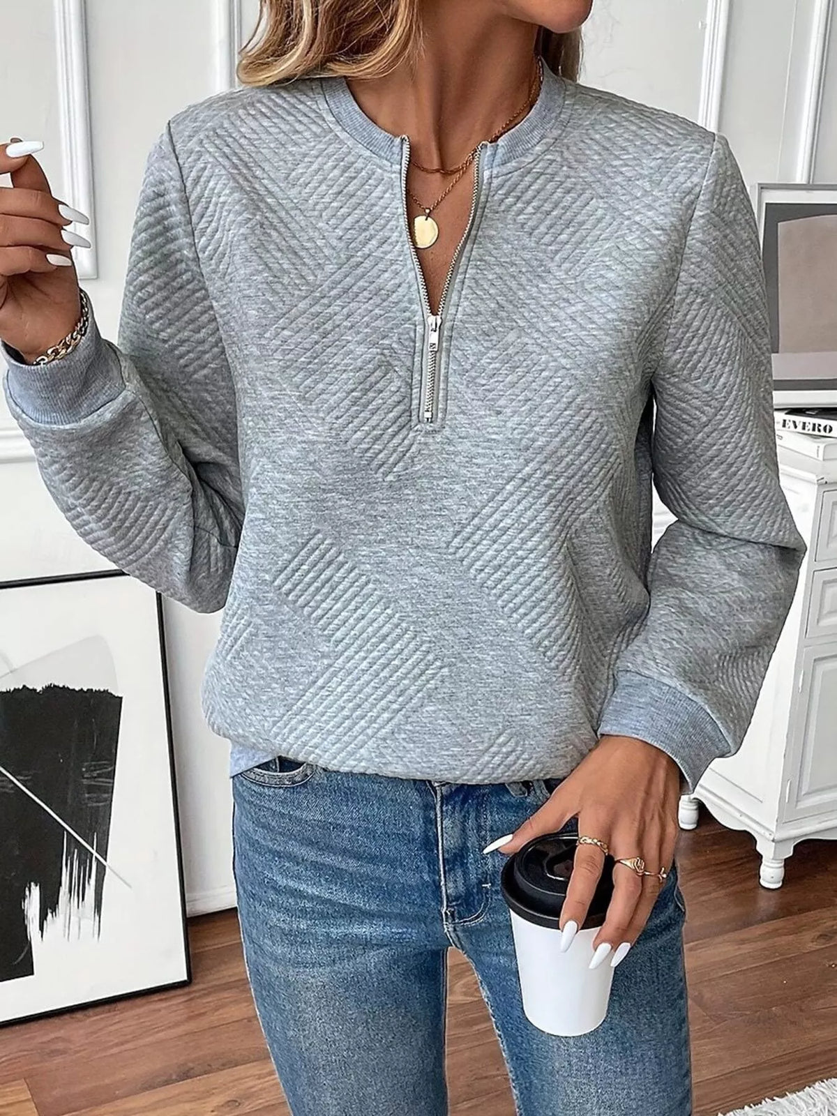 Textured women's quarter-zip sweatshirt by Trendsi, showcasing a close-up of the fabric and zipper detail.