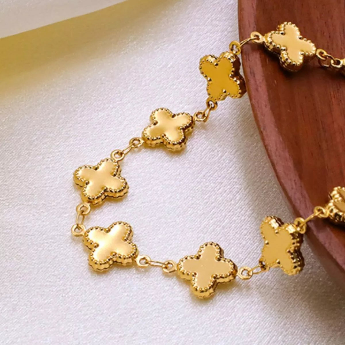 18K gold-plated clover charm necklace with delicate chain, showcasing a shiny four-leaf clover pendant on a plush fashion hub jewelry piece.