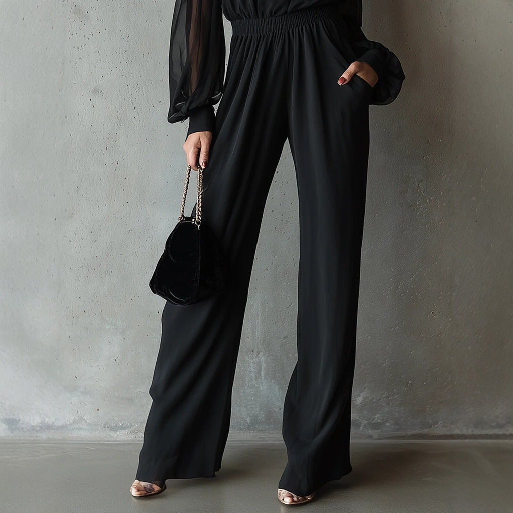Black embroidered women's long-sleeve wide-leg jumpsuit by FitiqueFit, showing its relaxed fit and detailed embroidery on the fabric.