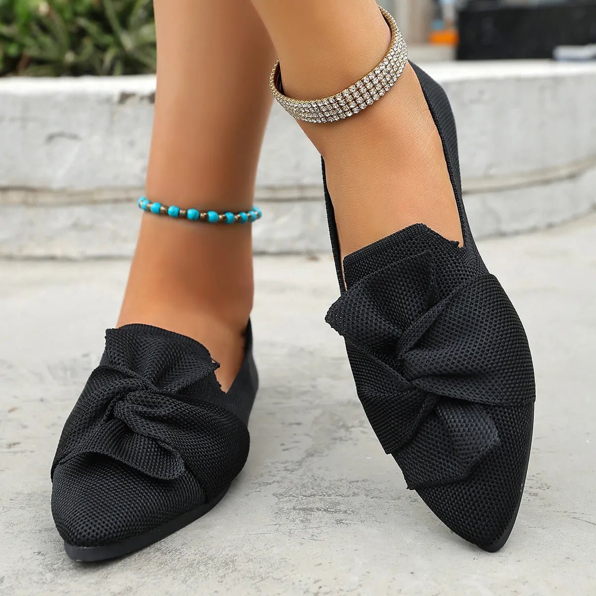 Elegant Plush Fashion Hub bow embellished pointed toe flat slip-on shoes showing a stylish design with a decorative bow detail.