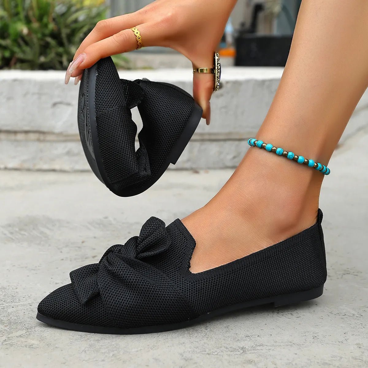 Elegant plush fashion hub bow-embellished pointed toe flat slip-on shoes on a neutral background