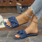 Women's denim flat sandals with bow tie detail and casual PU leather straps, comfortable slip-on shoes by Trendsi.
