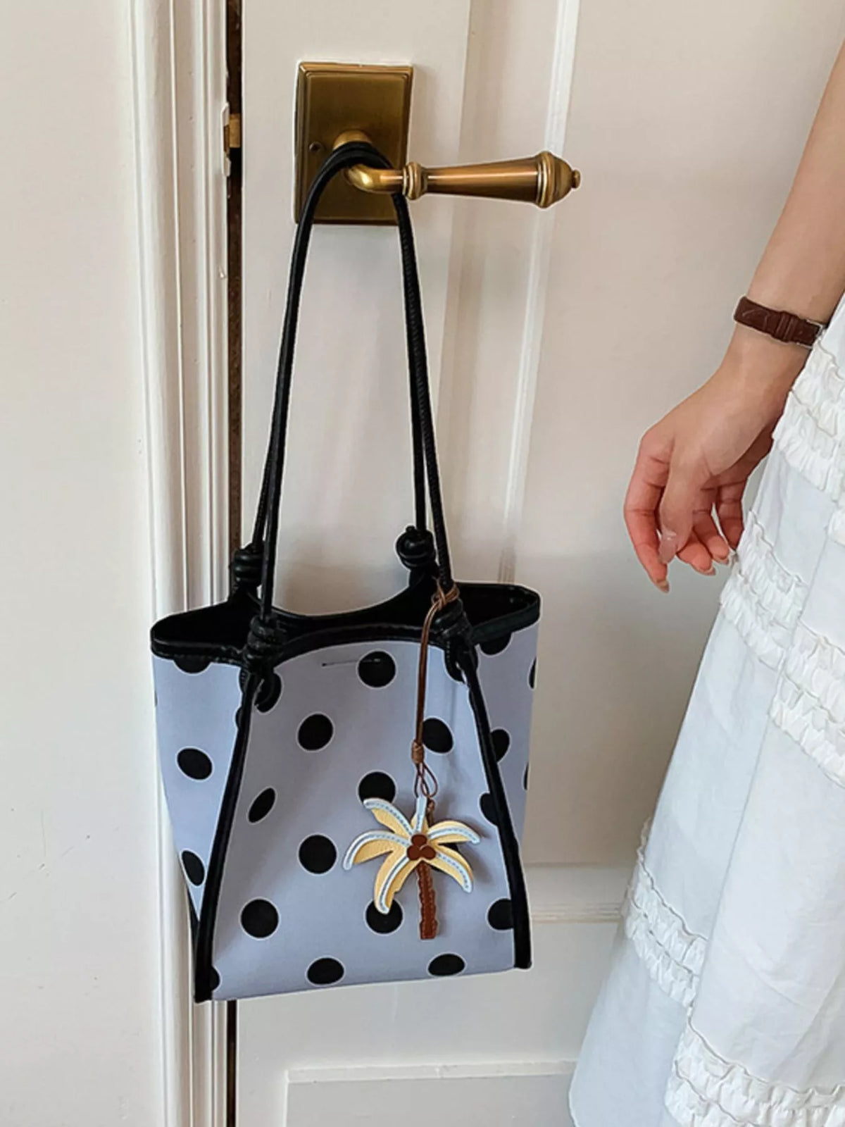 Polka dot shoulder handbag from Plush Fashion Hub, featuring a stylish design with a shoulder strap and polka dot pattern.