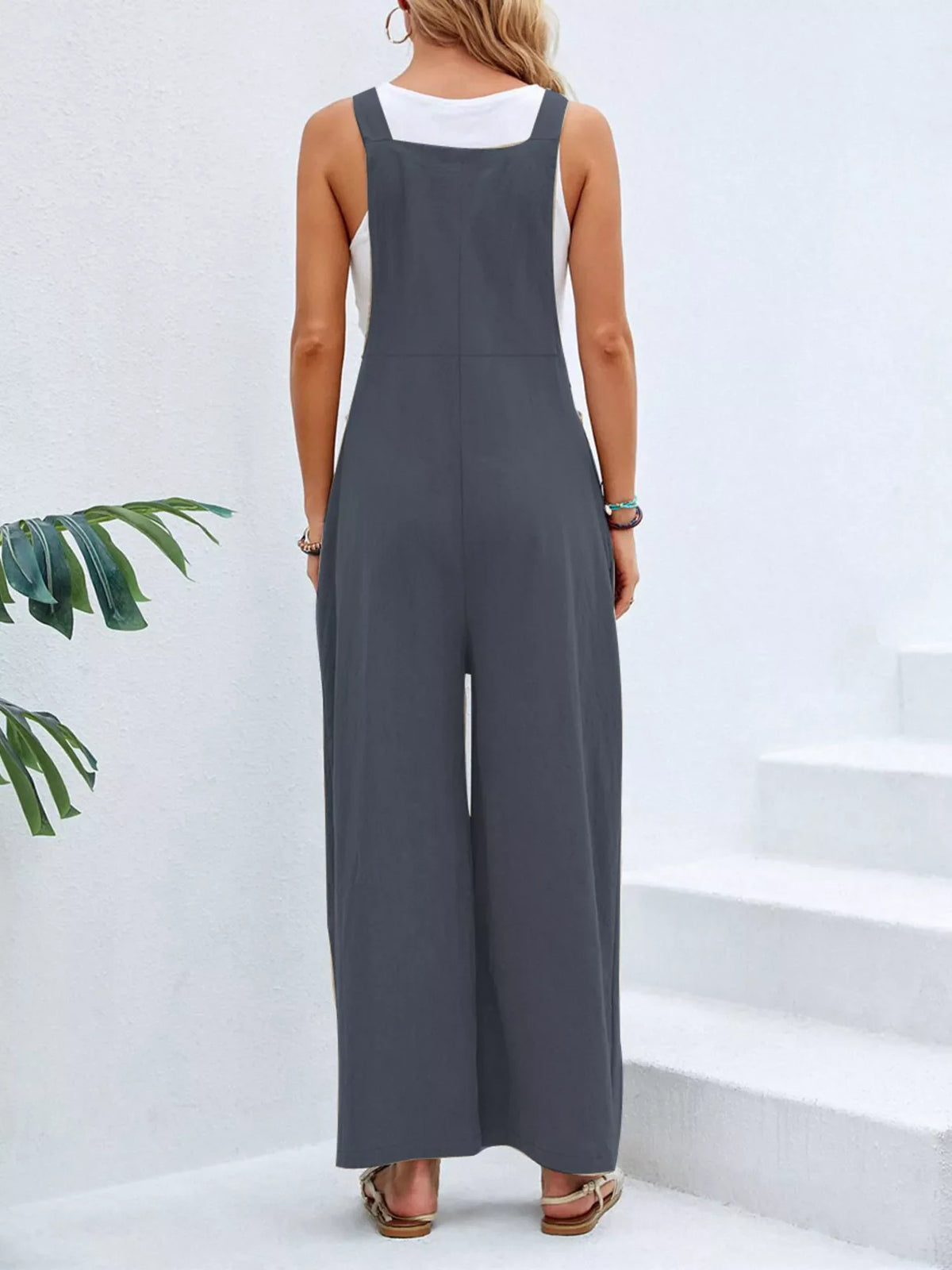 Plus size full size casual wide-leg jumpsuit with pockets from Plush Fashion Hub, featuring a comfortable, relaxed fit.