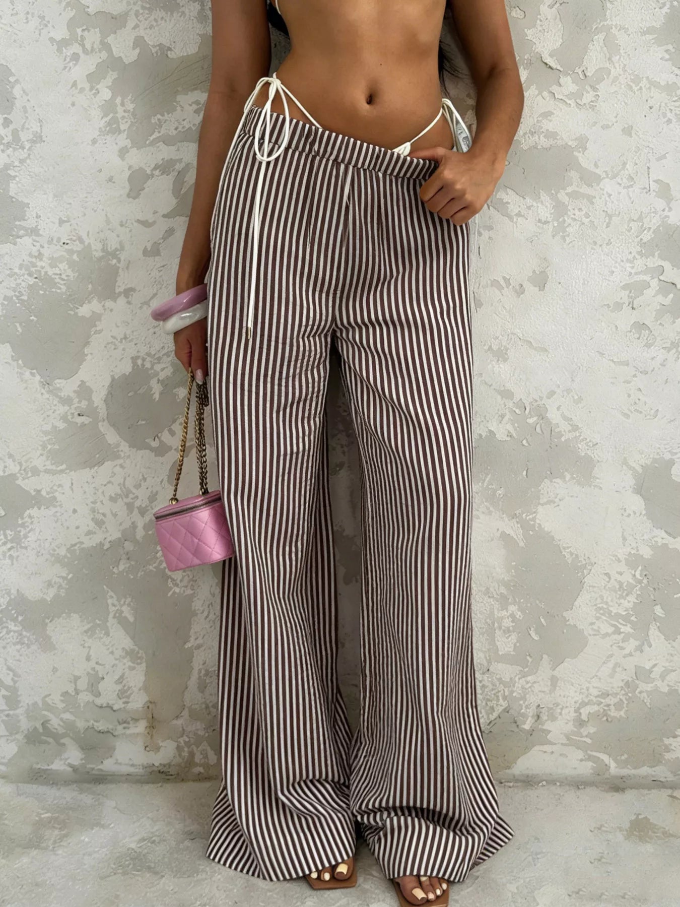 Striped wide-leg pants from Trendsi featuring a tied waist and relaxed fit, perfect for casual and stylish outfits.