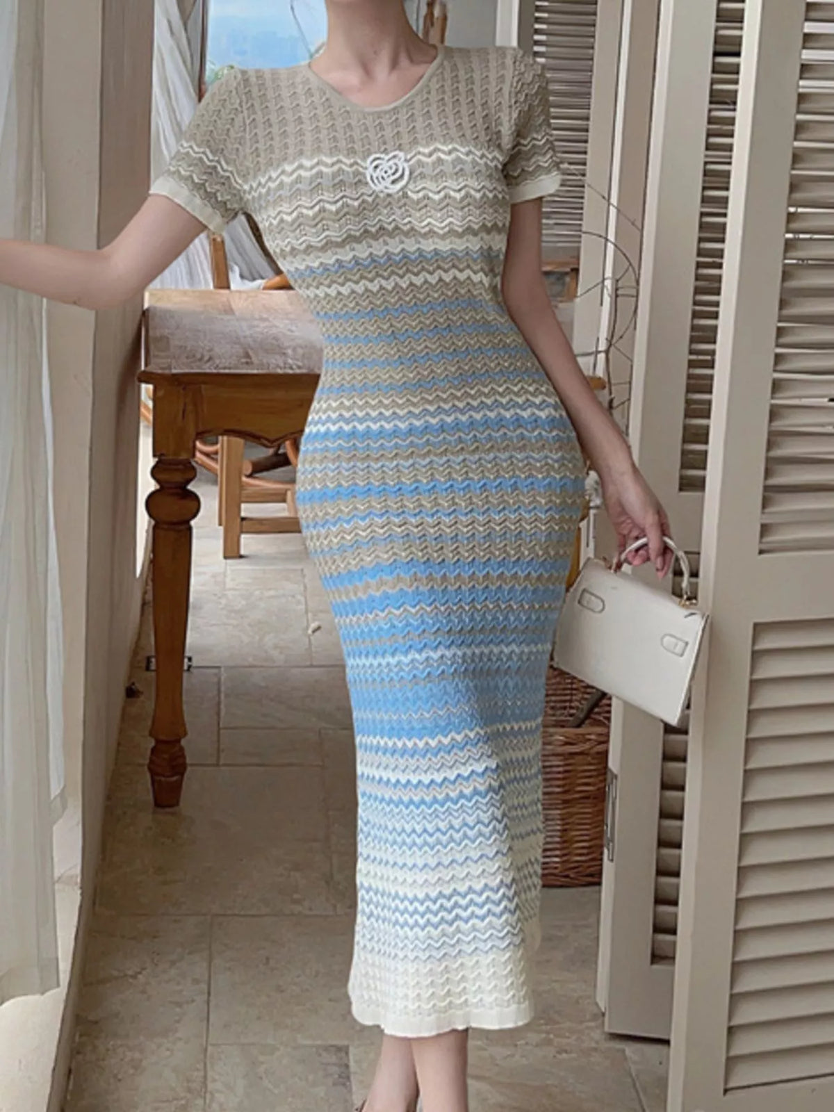 Gradient knit striped short sleeve midi dress by Trendsi, featuring a fitted bodice and flowing skirt with colorful horizontal stripes.
