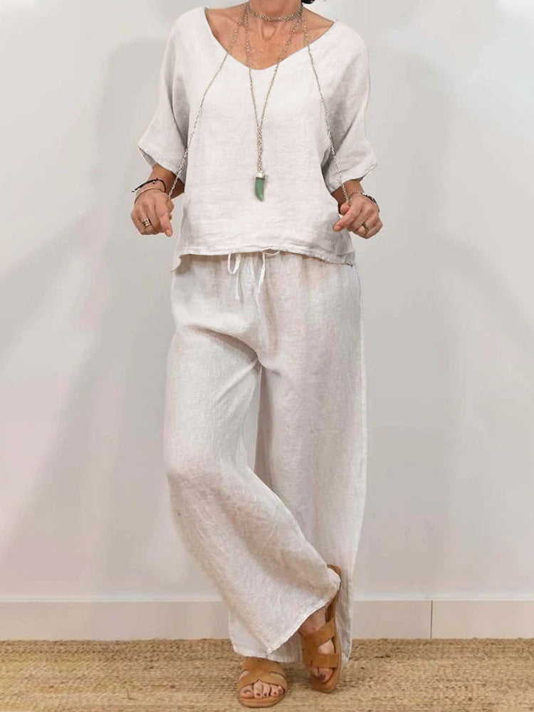 Multi-color women's casual two-piece set with a V-neck top and pants by Plush Fashion Hub, displayed on a hanger.