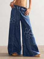 Shopimist floral appliqué wide leg jeans with decorative flower details and relaxed fit, showcasing stylish denim design.