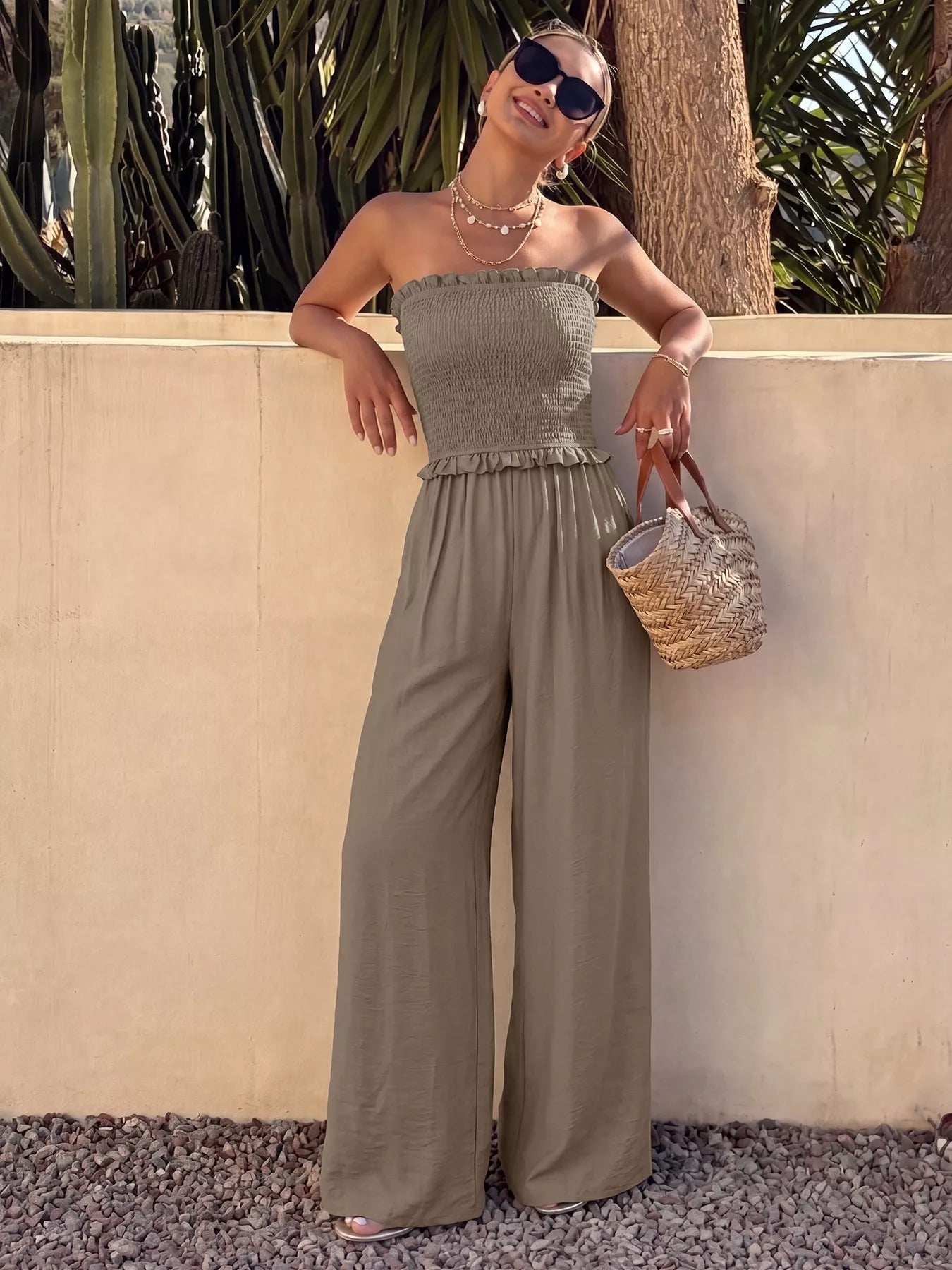 Smocked strapless wide-leg jumpsuit by Trendsi featuring a fitted bodice and flowing wide-leg pants, perfect for warm-weather wear.