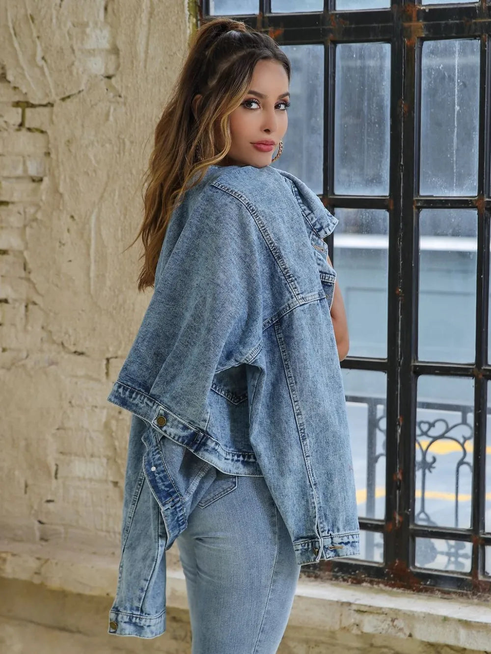 Drop shoulder denim jacket from Trendsi featuring button-down front and classic blue denim fabric, displayed on a hanger.