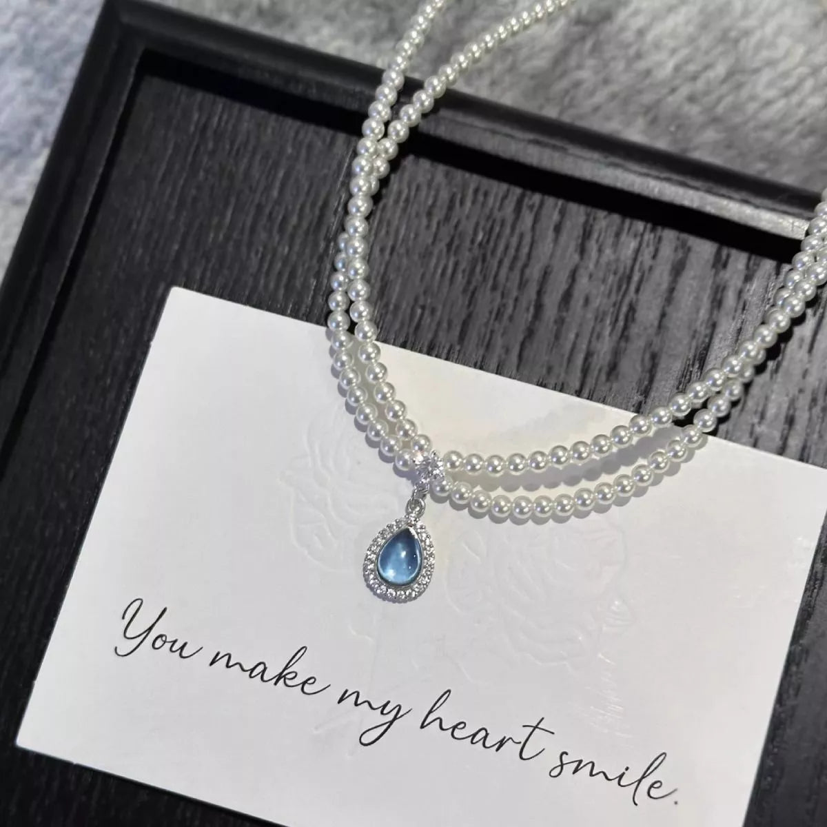Double layered pearl necklace with teardrop pendant from Plush Fashion Hub, featuring elegant pearls and a delicate pendant.