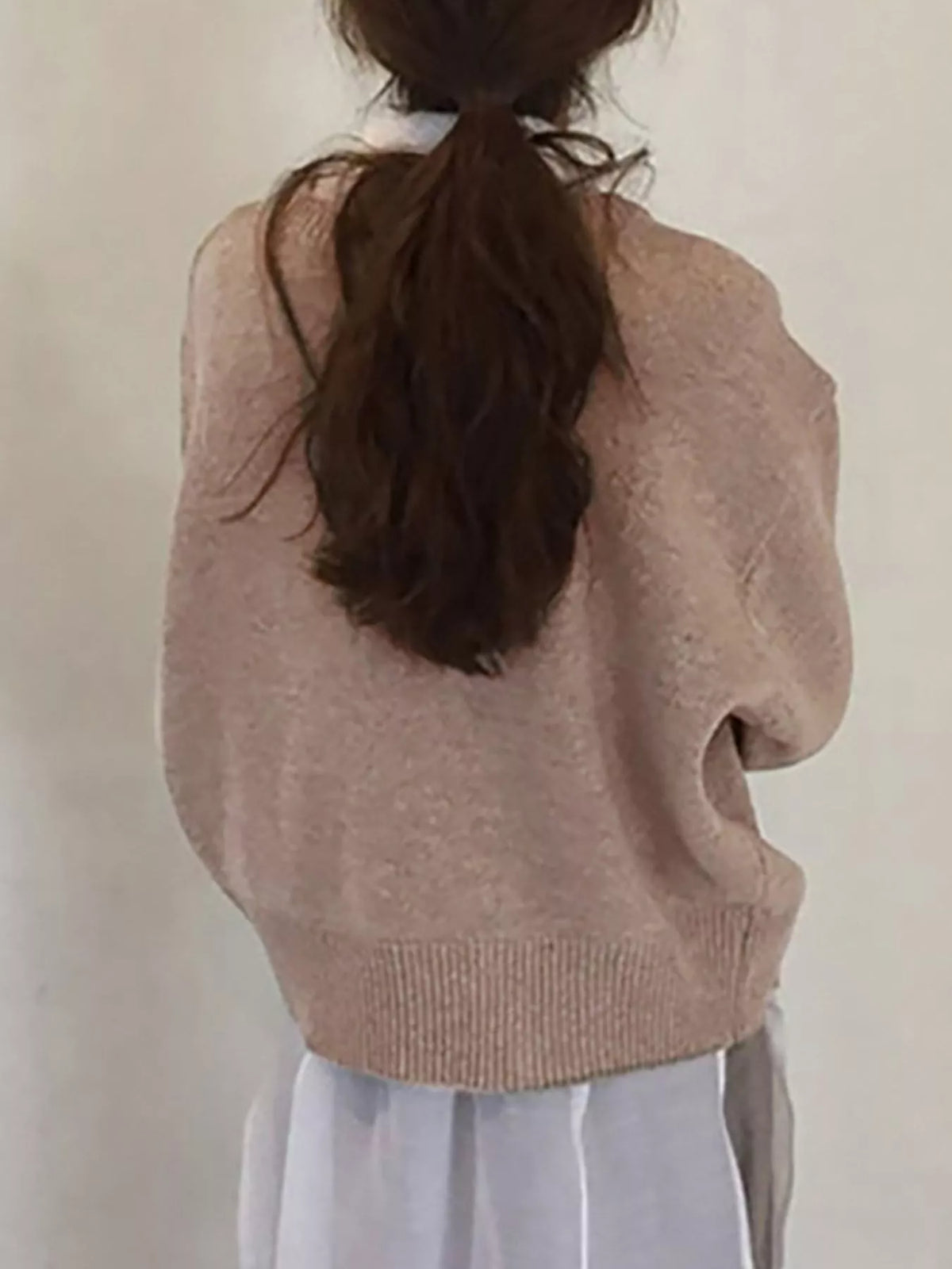 Asymmetric button-down sweater by Trendsi featuring a stylish design with unique button placement and a cozy knit texture.