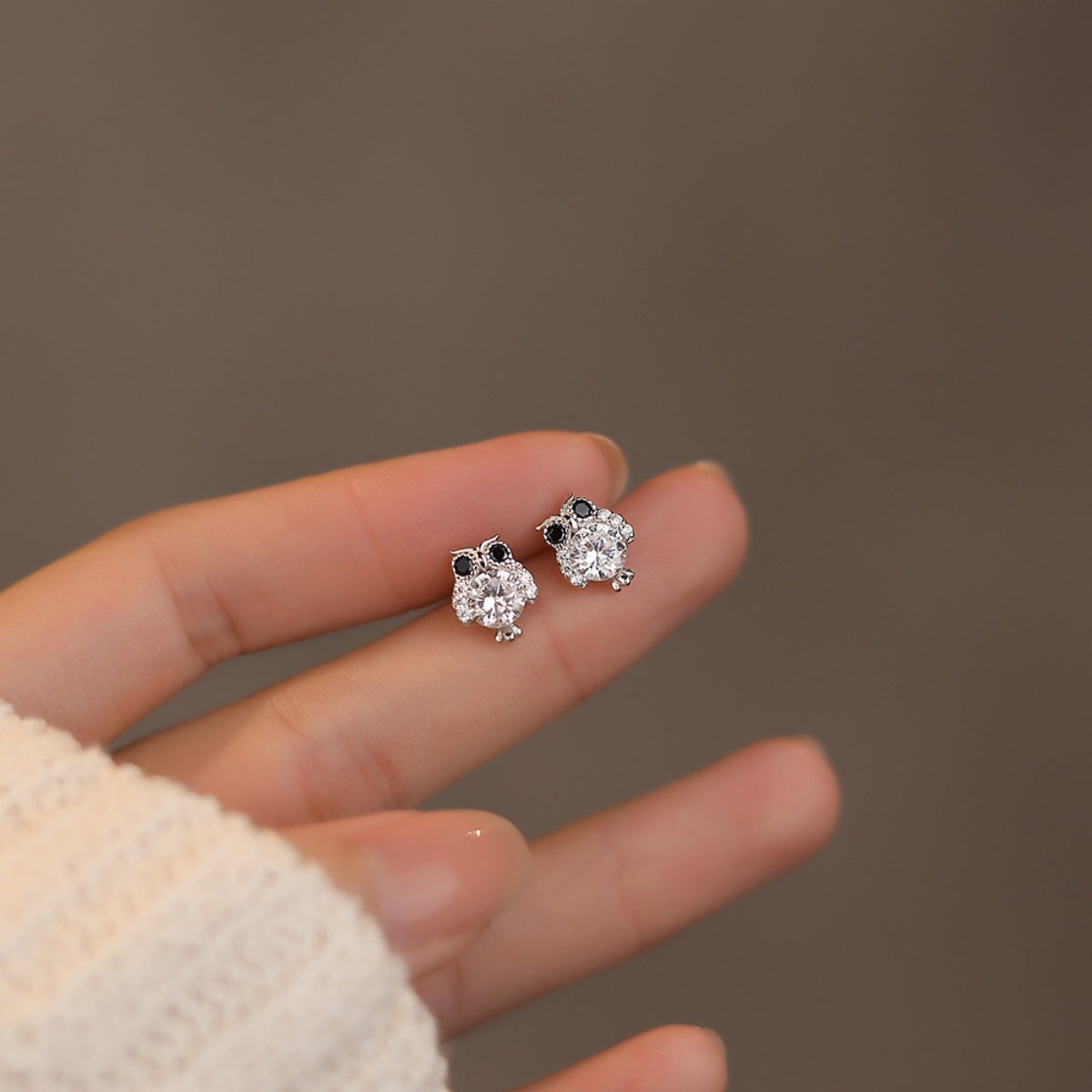 Plush Fashion Hub owl stud earrings featuring small, silver owl designs with detailed feathers on a white background.
