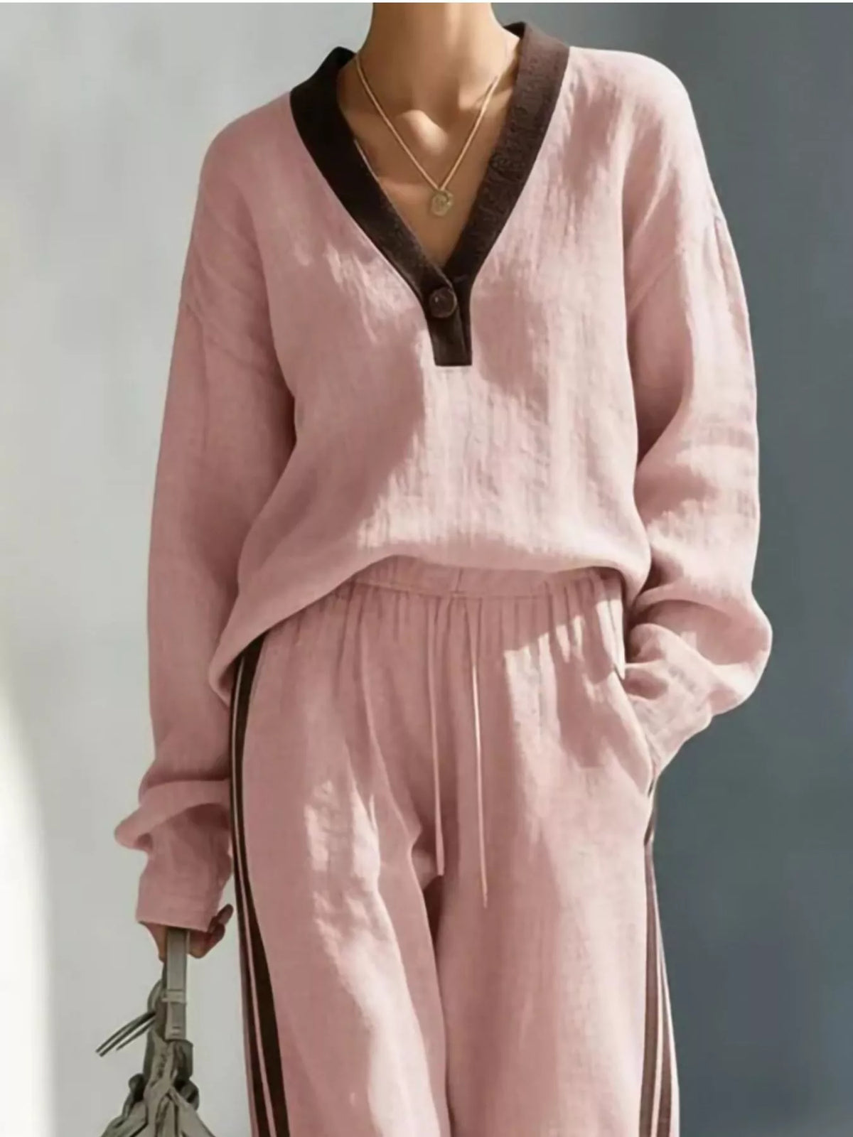 Women's contrast V-neck top and striped pants set, featuring a stylish coordinated outfit with a relaxed fit and trendy design.