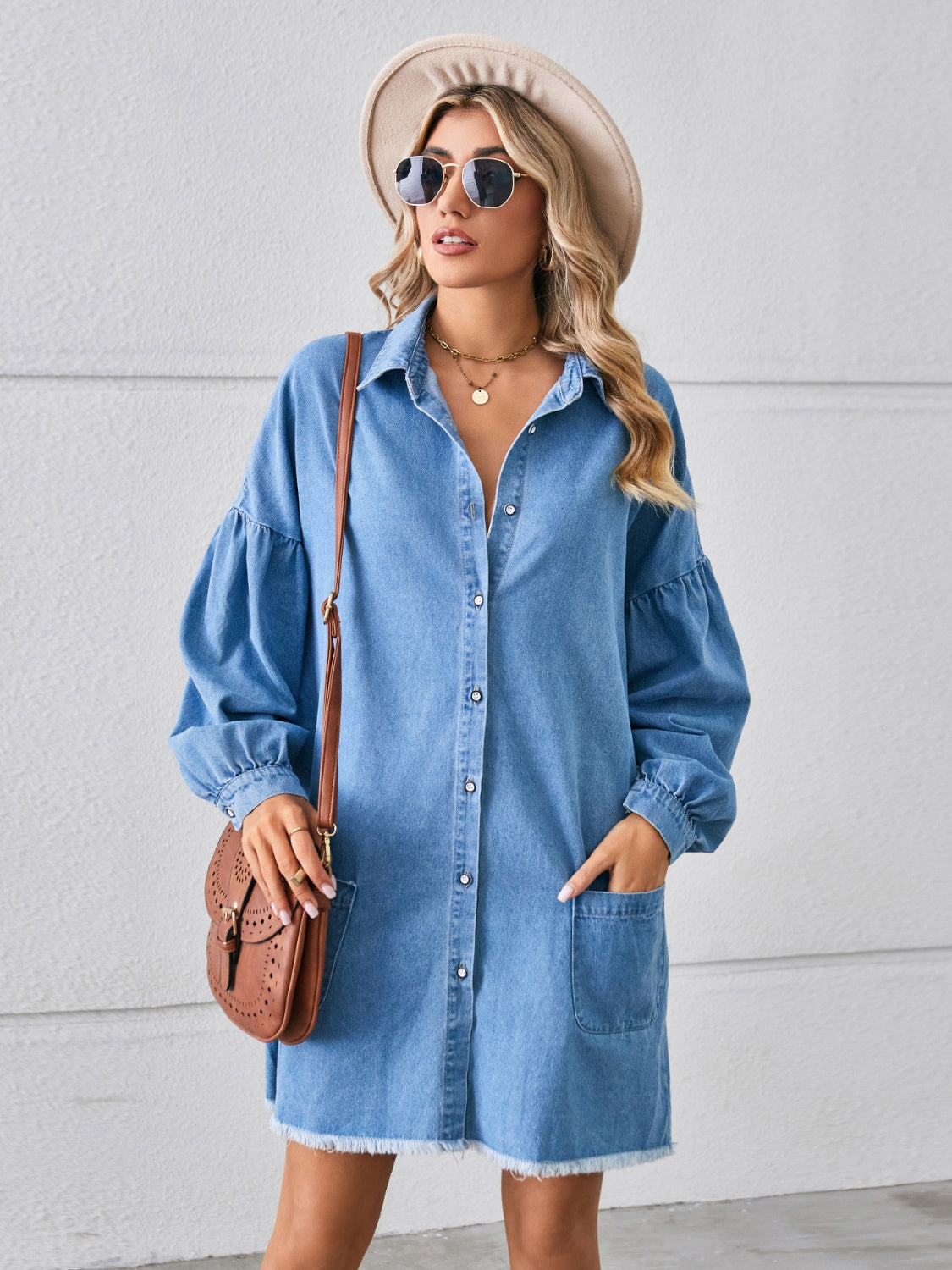 Button-up pocketed raw hem denim dress by Plush Fashion Hub, featuring a classic blue denim fabric and front chest pockets.