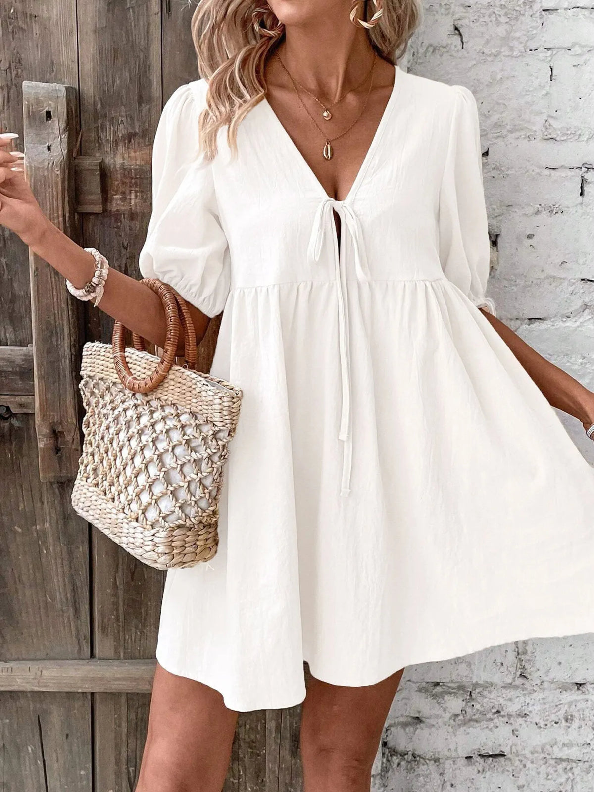 Cotton V-neck tie-front mini dress with puff sleeves from Plush Fashion Hub, showcasing a stylish and comfortable summer look.
