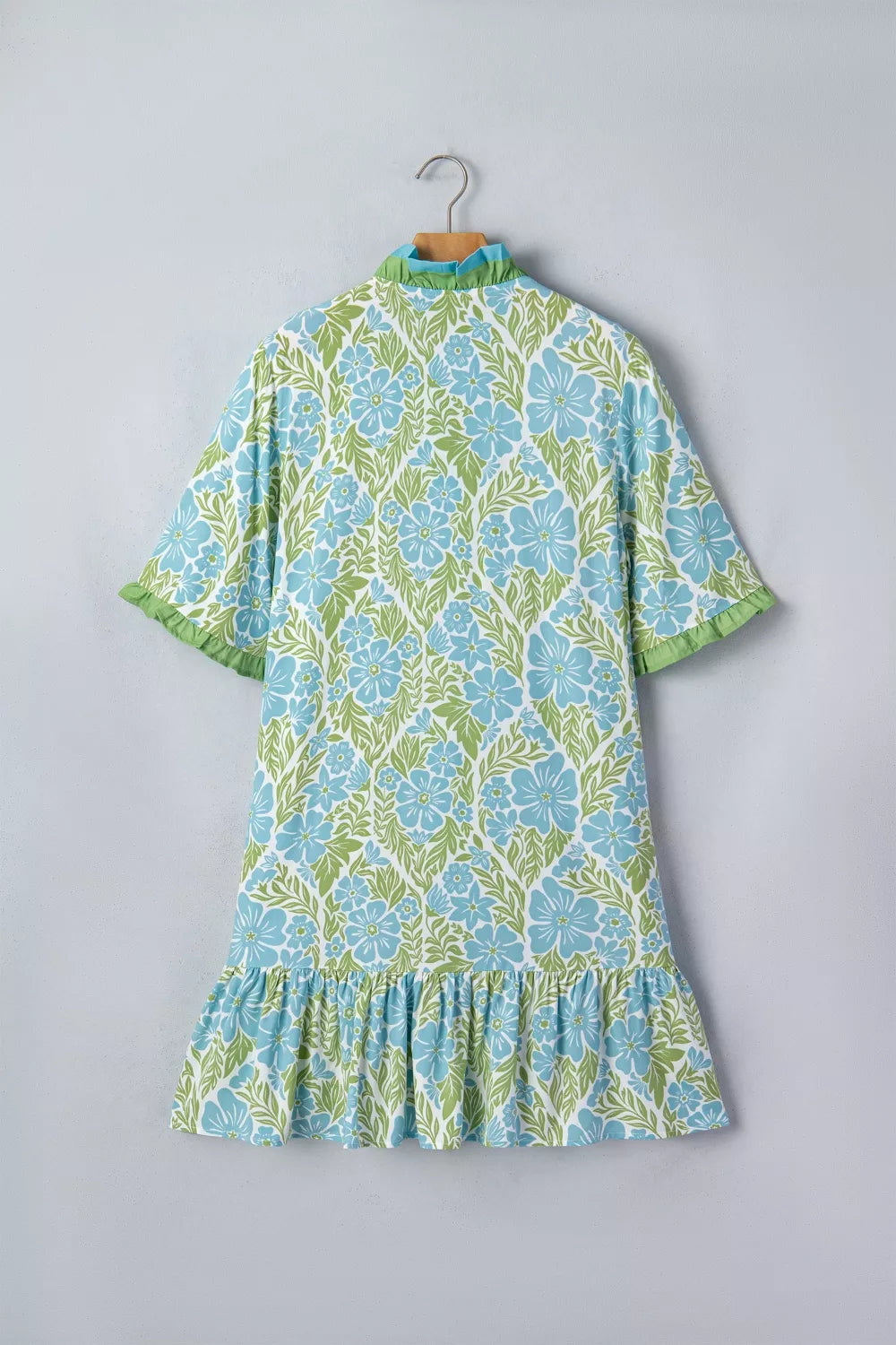 Floral print ruffle hem button-up mini dress by Trendsi, featuring a V-neckline, short sleeves, and a playful, feminine design.