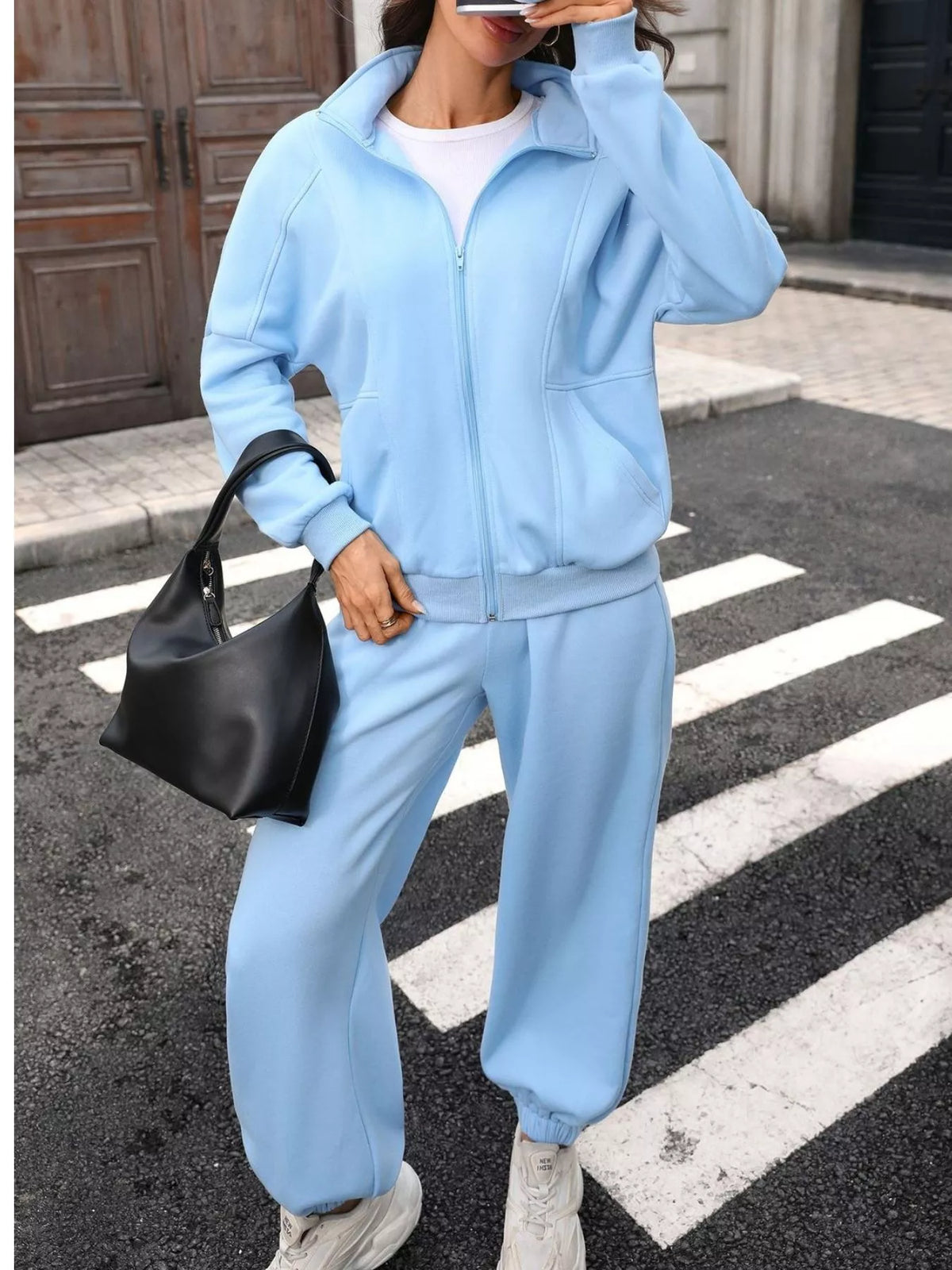 Women's zip-up long sleeve top and pants set by Trendsi, featuring a comfortable, coordinated outfit in soft fabric.